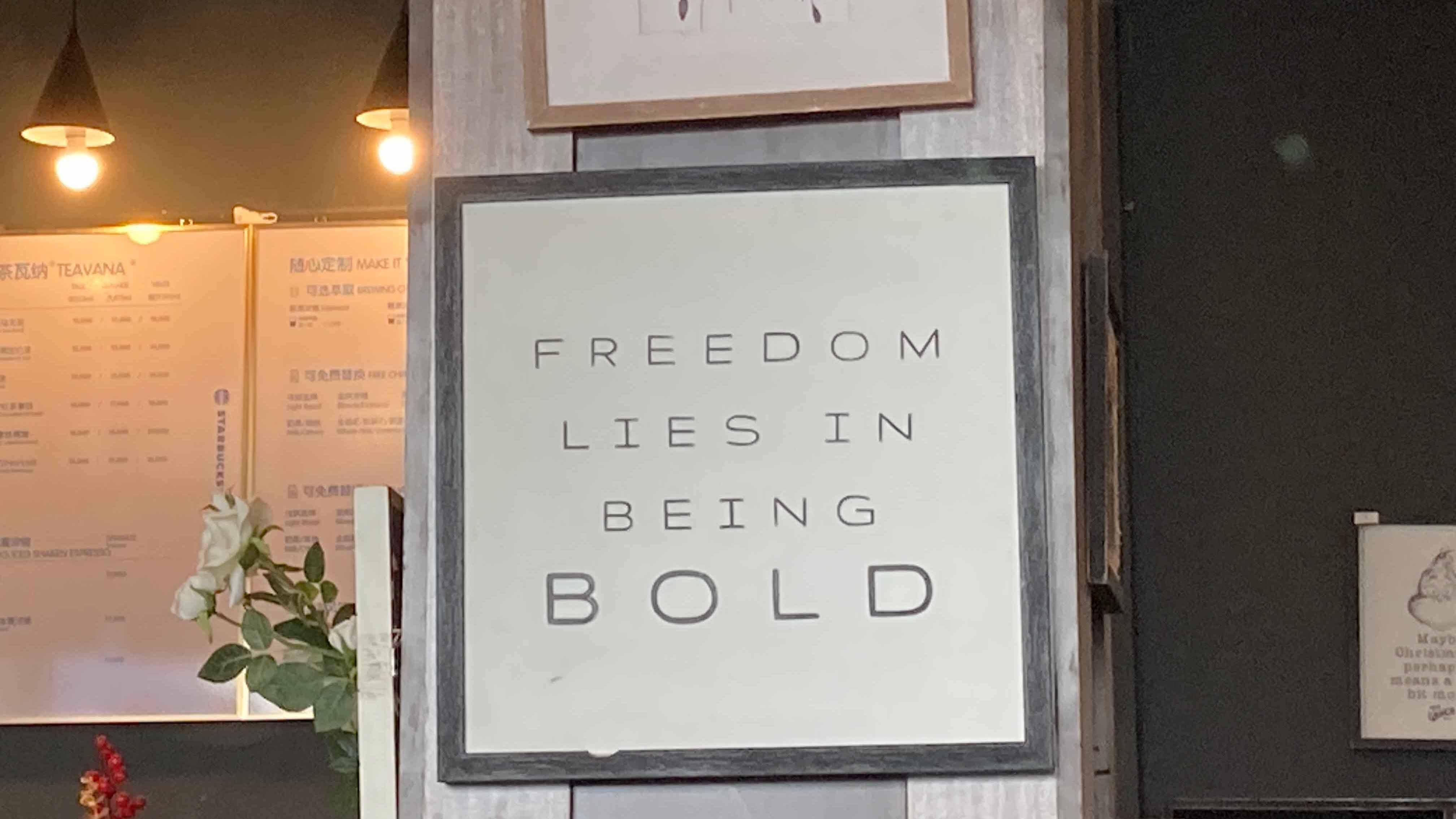 Wall art inside the store featuring the quote “FREEDOM LIES IN BEING BOLD” framed on a pillar.