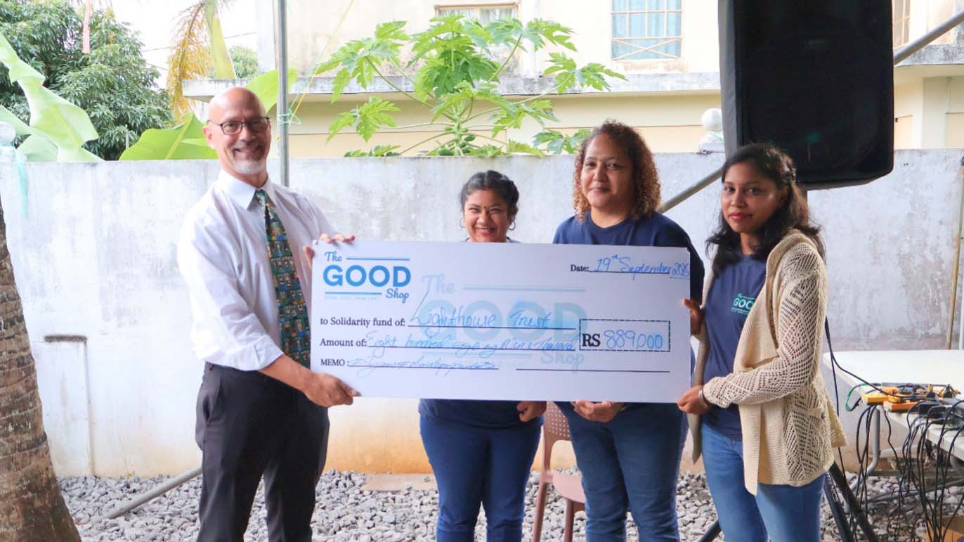 The Good Shopの代表者たちが、設立7周年イベントでLighthouse Trustに対し889,000モーリシャス・ルピーの寄付金を象徴する大型の小切手を手渡している。脆弱な家庭の子どもたちへの教育奨学金支援の一環。