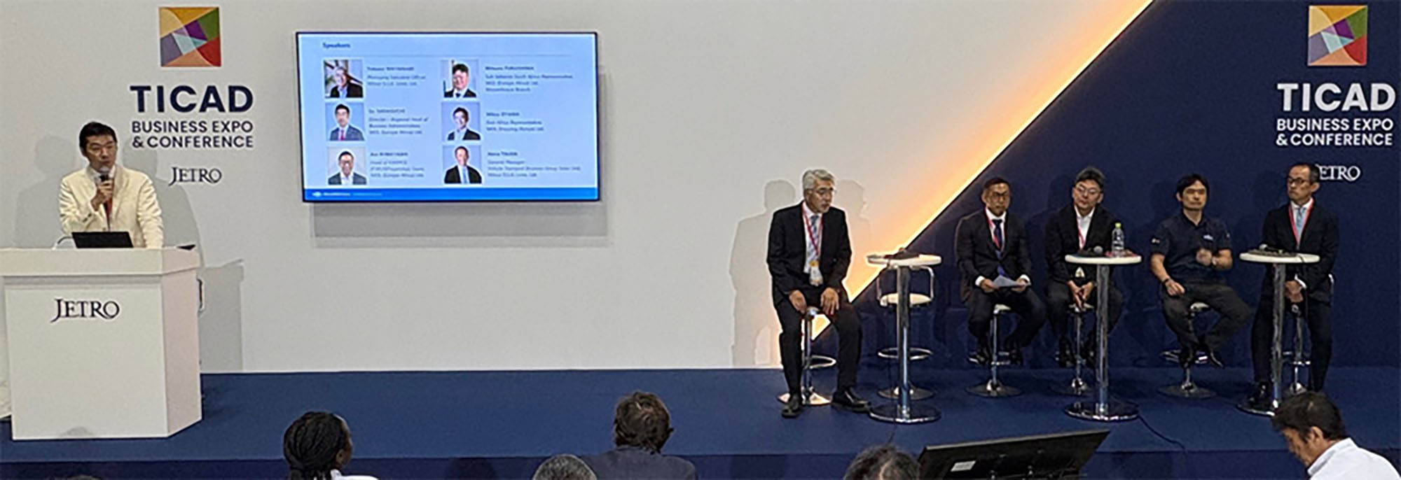 A panel discussion at the TICAD 9 Business Expo & Conference, with speakers seated on stage and a moderator introducing them.